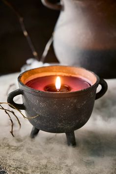 a candle is sitting in a pot on a table