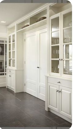 an empty room with white cabinets and wood floors