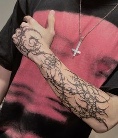 a man with a cross tattoo on his arm