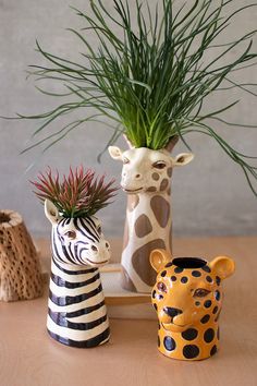 two giraffes and a zebra sitting next to each other on a table