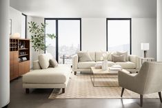 a living room filled with furniture and large windows