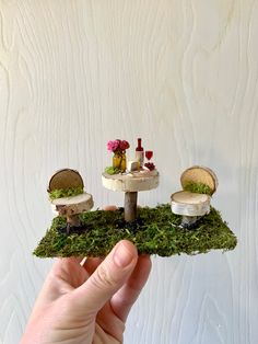 a miniature table and chairs made out of moss