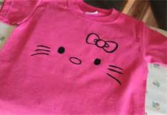 a pink t - shirt with a cat face drawn on it