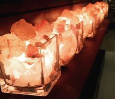 there are many rocks in glass vases on the table