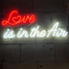 a neon sign that says love is in the air