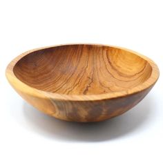 a wooden bowl sitting on top of a white table