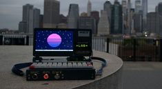 an electronic device sitting on top of a cement wall in front of a city skyline