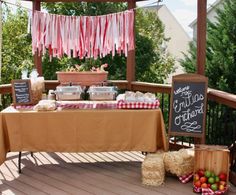 a table with food on it and some signs hanging from the ceiling over it,