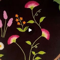 a black plate with pink and white flowers painted on it