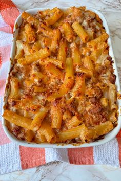 a casserole dish filled with macaroni and cheese on a checkered table cloth