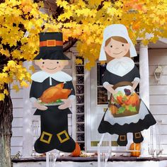 two inflatable thanksgiving decorations are on the front porch of a house with yellow leaves