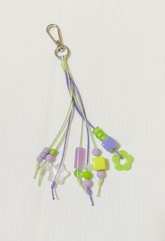 several earbuds hanging from a cord on a white surface with a green and purple string