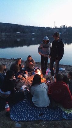 a group of people sitting around a campfire