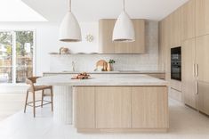 a kitchen with two pendant lights hanging over the island