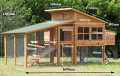 a wooden chicken coop with a green roof and stairs leading up to the top floor