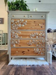 a dresser with flowers painted on the drawers and white fur rug in front of it