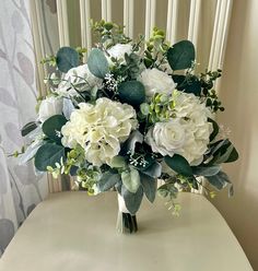 a bouquet of white flowers sitting on top of a table next to a radiator