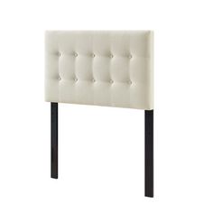 an upholstered headboard with black legs and buttons on the top, against a white background