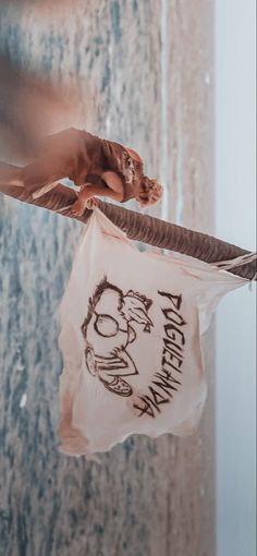 a bag hanging from a clothes line with an image of a man holding a bird on it