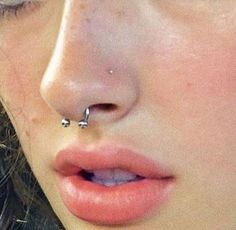 a woman with piercings on her nose looking at the camera