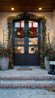 the front door is decorated for christmas with wreaths and bows on it's doors