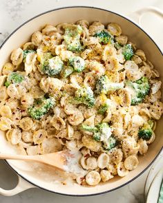 a pot filled with pasta and broccoli on top of a table