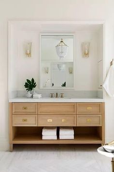 a bathroom with two sinks and a large mirror above the sink is decorated in gold