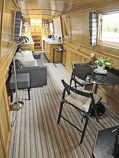 the interior of a house with wood paneling and striped carpeted flooring, including a dining area