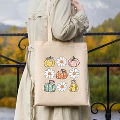 Celebrate autumn with the Cutest Pumpkin In The Patch Canvas Tote Bag—a stylish and eco-friendly accessory that perfectly captures the season’s charm. Made from 100% cotton canvas, this tote showcases a playful pumpkin design, making it the perfect companion for your fall outings. Whether you're off to the market, enjoying a crisp autumn walk, or just running errands, this durable bag provides ample space for your essentials while promoting sustainability. Features: Size: 14 1/2" W x 15 1/2" H w Fall Outings, Cutest Pumpkin In The Patch, Autumn Walk, Eco Friendly Accessories, Fall Feels, Crisp Autumn, Cute Pumpkin, Trendy Tee, Pumpkin Design