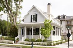 a white house sitting on the corner of a street