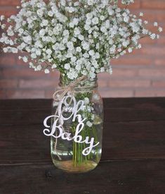 baby's breath in a mason jar with the word oh baby written on it