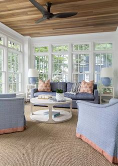 a living room filled with furniture and lots of windows