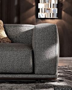 a gray couch sitting on top of a carpet covered floor