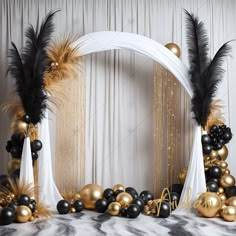 an arch decorated with black, gold and white balloons is surrounded by golden and silver decorations