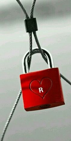 a red padlock attached to a rope with a heart on it's side