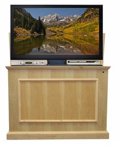 a flat screen tv sitting on top of a wooden entertainment center next to a lake