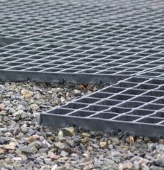 a grate laying on the ground with rocks and gravel