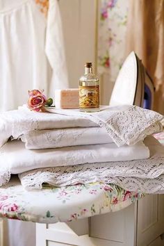 a stack of white towels sitting on top of a ironing board