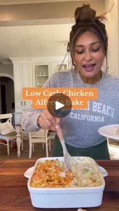 a woman is eating food from a white dish on a wooden table in the kitchen