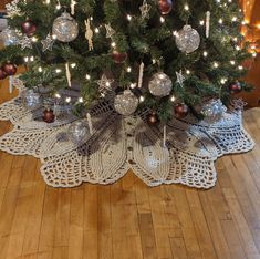 a small christmas tree with ornaments and lights on the top is sitting on a wooden floor