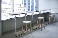 three stools are lined up in front of a window