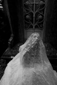 a large rock sitting in front of a door covered in plastic covering it's head