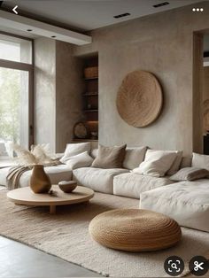 a living room filled with lots of white furniture and large round mirrors on the wall