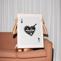 a woman sitting on a couch holding up a framed poster with the words imagine music