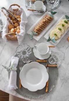 the table is set with plates, silverware and breadsticks on it's placemat