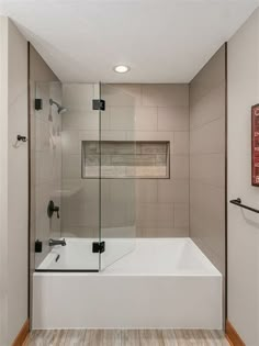 a bathroom with a bathtub, shower and wooden flooring in the middle of it