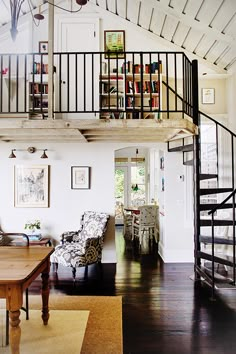 a living room filled with furniture and a spiral staircase leading up to the second floor