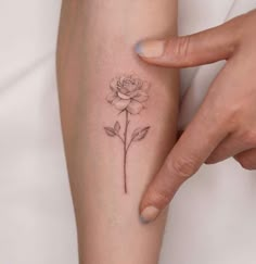 a woman's arm with a rose tattoo on the left side of her body