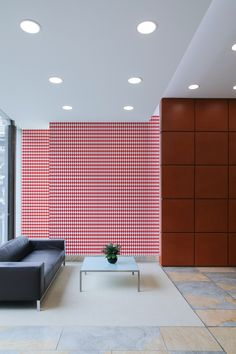 a modern living room with red and white checkered wall paper behind the couches