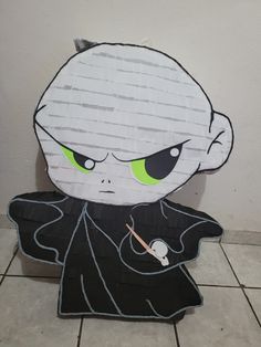 a paper cut out of an evil character with green eyes